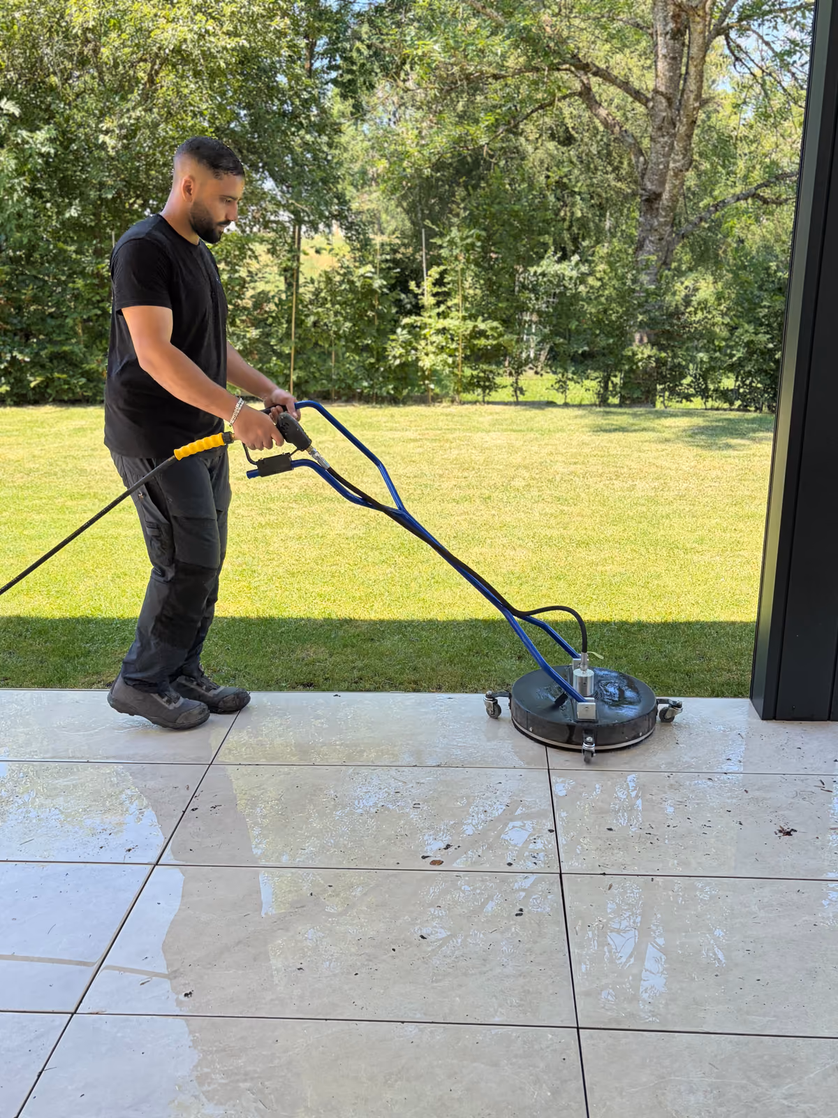 Blitzeblank employee cleaning terrace slabs with a surface cleaner